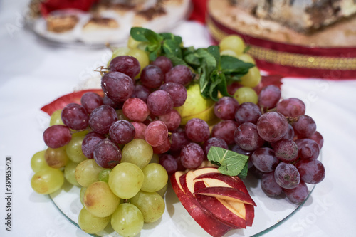 Top view of a decorated banquet table with grapes of different varieties for a corporate birthday or wedding celebration.