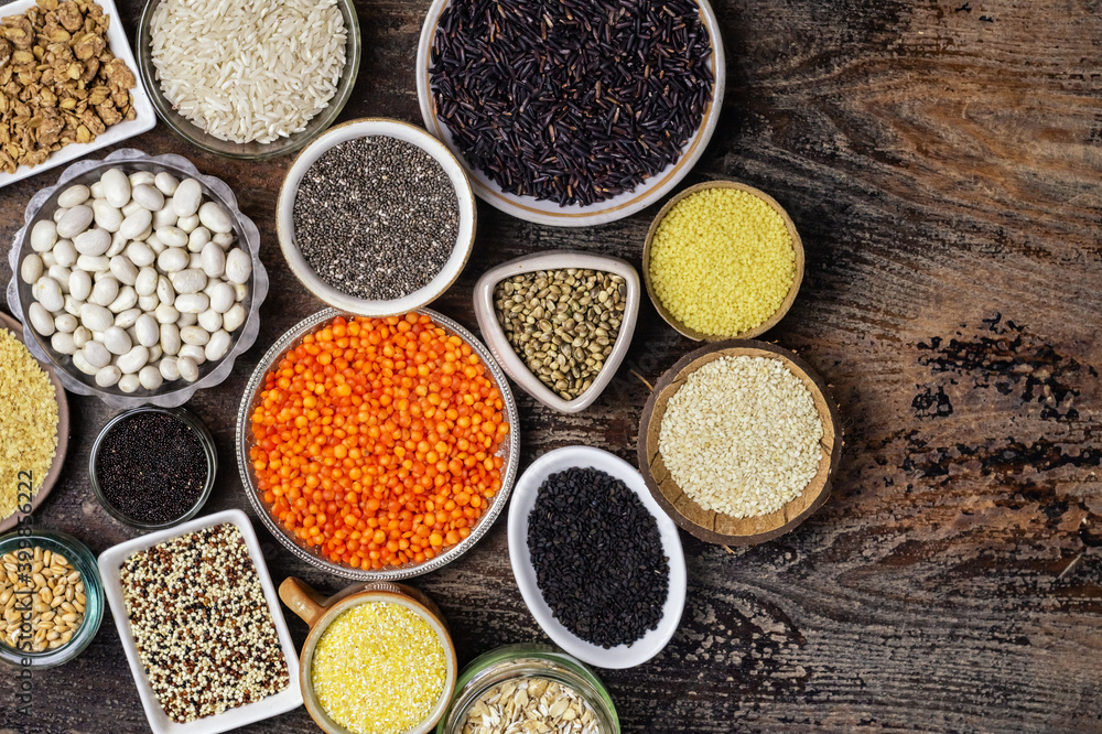 Food background of various cereals and grains in plates on a wooden table Food background of various cereals and grains in plates on a wooden table