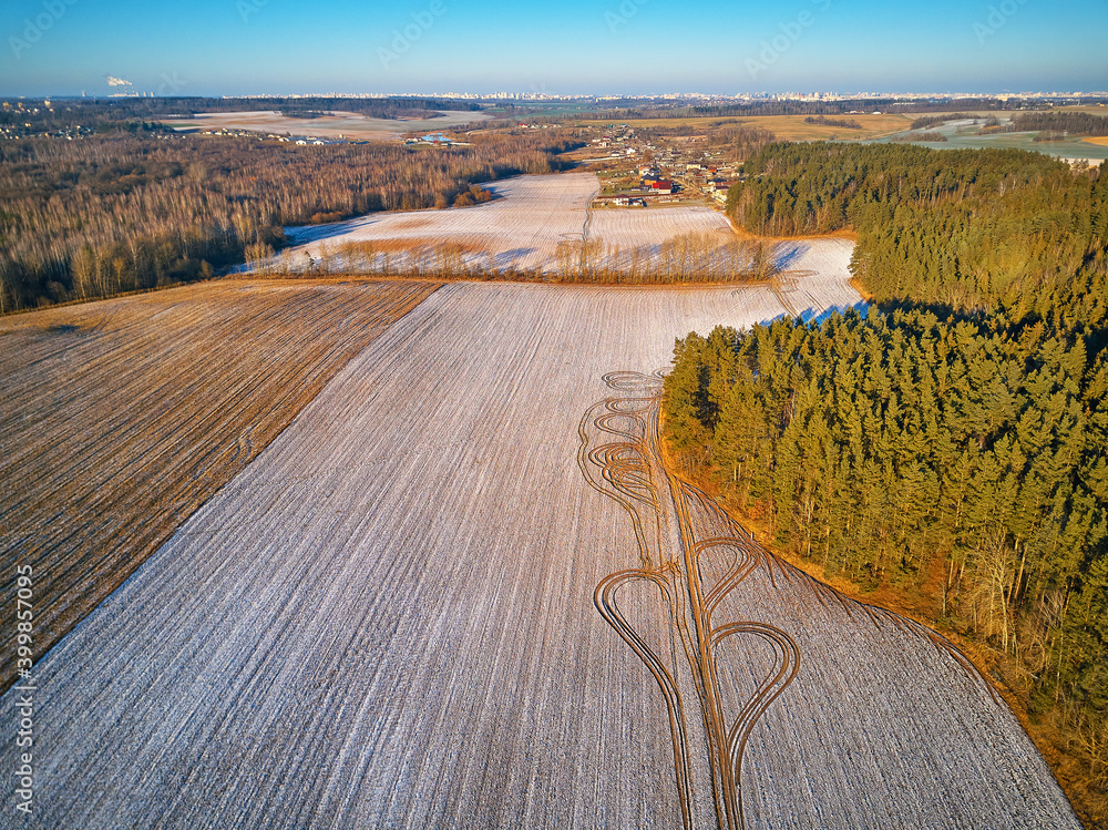 Winter Agricultural field under snow. Aerial scene. December Rural landscape.