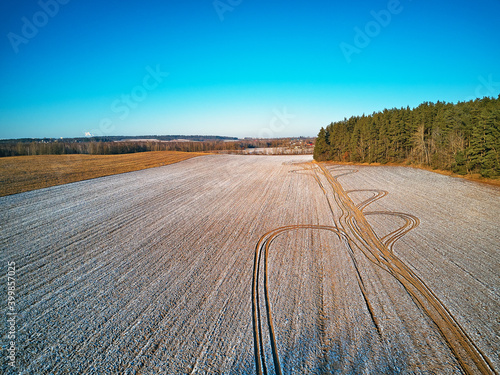 Winter Agricultural field under snow. Aerial scene. December Rural landscape.