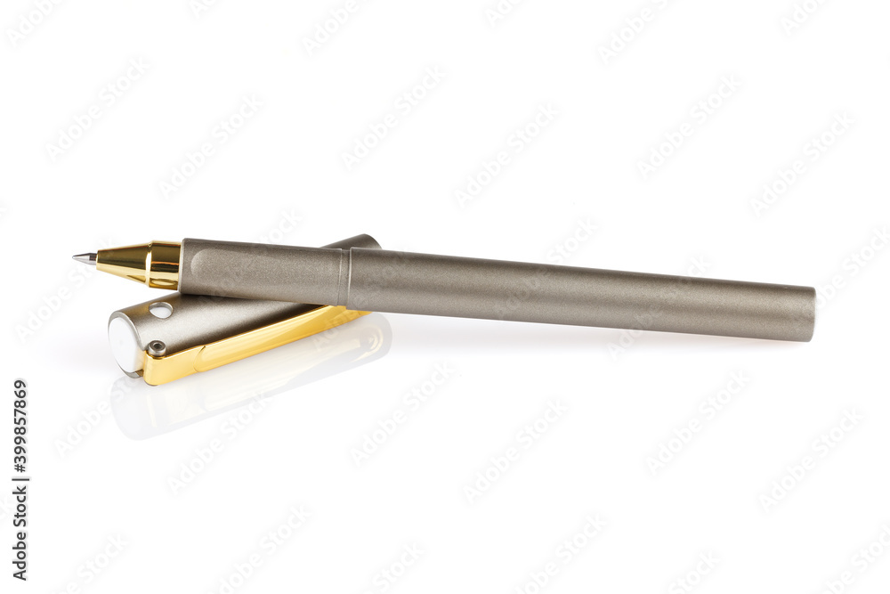Gray ballpoint pen lying on a cap isolated on a white background. Close-up. Gray ballpoint pen lying on a cap isolated on a white background. Close-up.