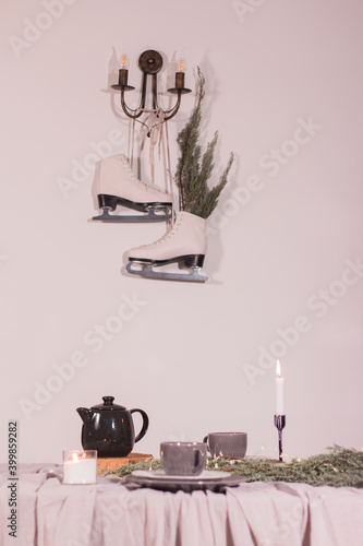 Beautiful christmas composition with a candles, decorations on textured table. Skates hang in the background. Close up, copy space, background.