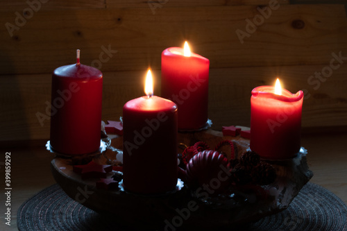 Rote brennende Kerzen auf einem Adventsgesteck. Es ist der dritte Advent. Bald ist Weihnachten. photo