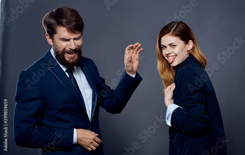 Business man and woman in suit gesturing with hands on gray background cropped view