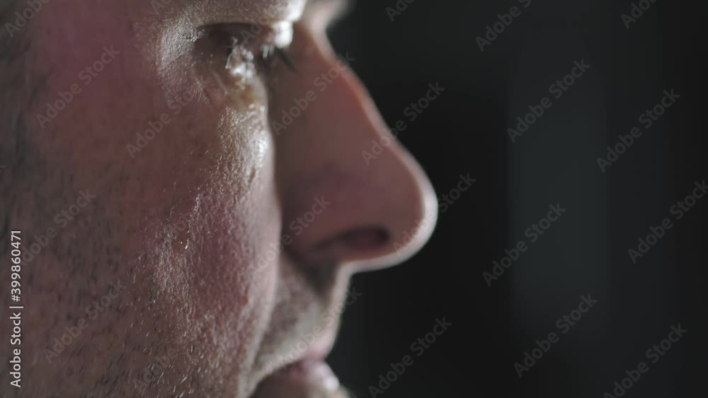 Close-up of a man's cheek with a tear sliding down it. A tear slowly descends on the distressed face of a men, macro. Close-up of a man's cheek with a tear sliding down it. A tear slowly descends on the distressed face of a men, macro.