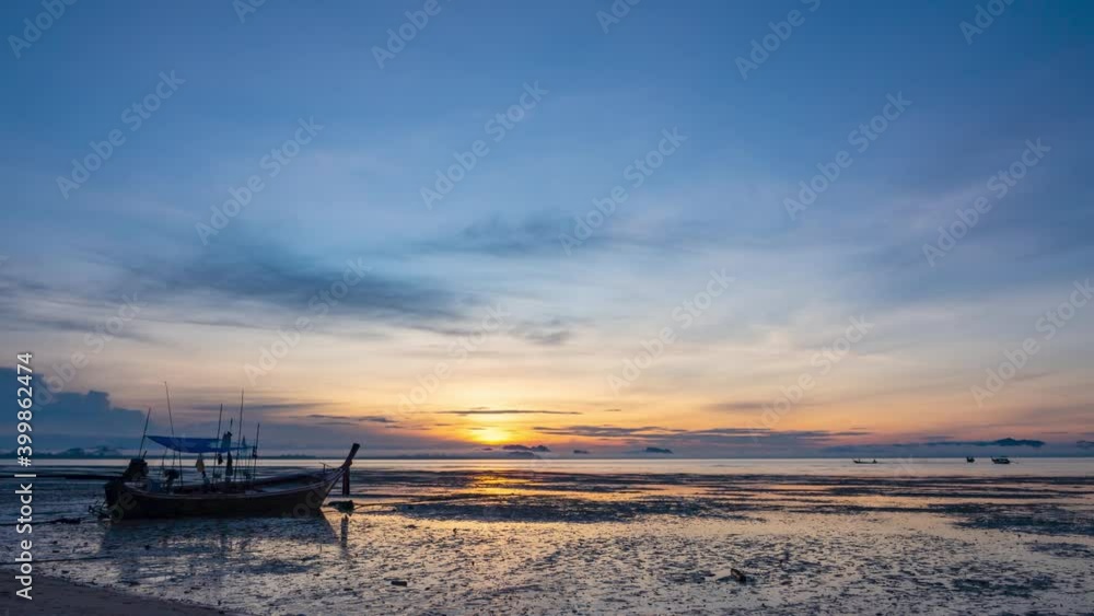 Beautiful sunrise in seaside in fisherman village in southern island in Thailand. Fishing boat standing on sand with golden down light reflected on sea water and shore. Lifestyle nature background Beautiful sunrise in seaside in fisherman village in southern island in Thailand. Fishing boat standing on sand with golden down light reflected on sea water and shore. Lifestyle nature background