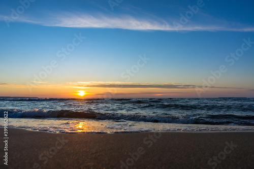 Sunset over the sea. Reflection of sunlight in the sea waves. The sky in the sunset rays. Baltic Sea.