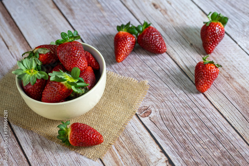 Strawberries in a bowl on top of a wooden table