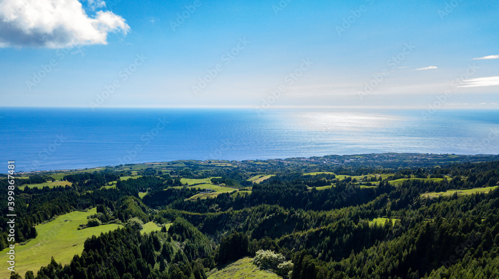 Landscape view over the luxurious green landscape with the Atlantic Ocean in the background. São Miguel Island. Azores.