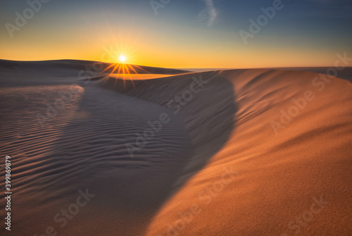 Moving dunes in the S  owi  ski National Park during sunset. Amazing textures on sand bathed in golden light.