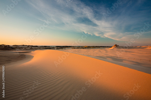 Moving dunes in the Słowiński National Park during sunset. Amazing textures on sand bathed in golden light. © PawelUchorczak