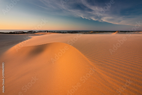 Moving dunes in the S  owi  ski National Park during sunset. Amazing textures on sand bathed in golden light.