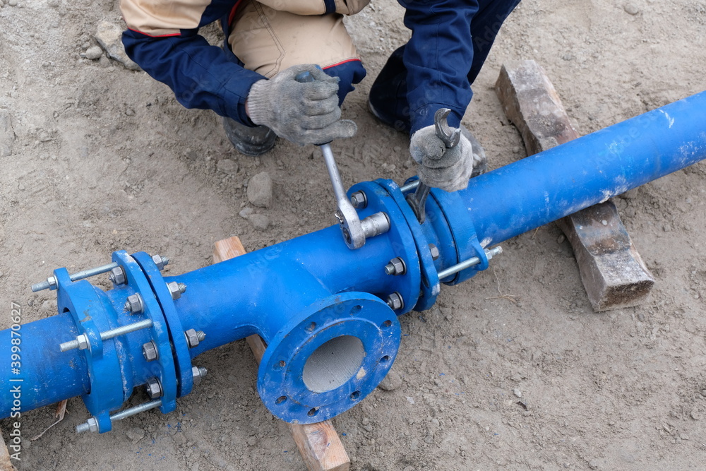 Fototapeta premium Workers installing water supply pipeline system, close up