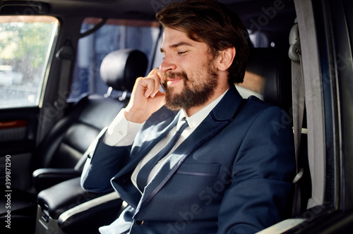 happy man talking on the phone in car portrait close-up suit