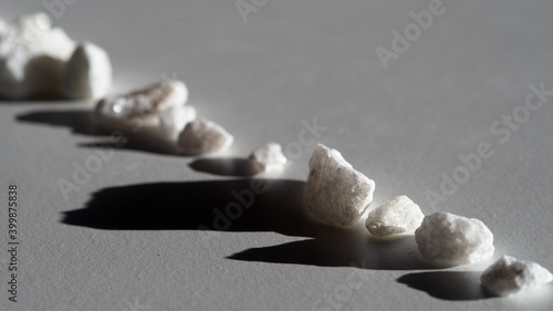 Canvas Print A row of light stones with a shadow on a light surface.