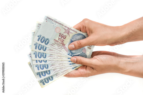 Hands holding Turkish lira bills isolated on white background. Counting or spend money.