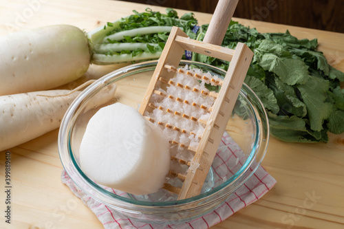 Grating daikon radish with traditional japanese bamboo grator photo