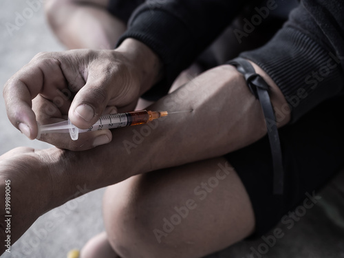 Narcotic Recreational drugs concept. Black and white image of Hard drugs with hand holding Injecting heroin into a vein.