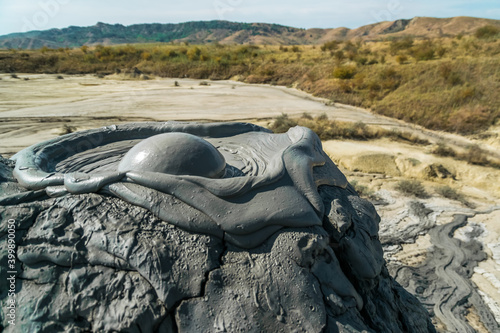 Foto Active mud volcano eruption with a mud bubble captured in Romania