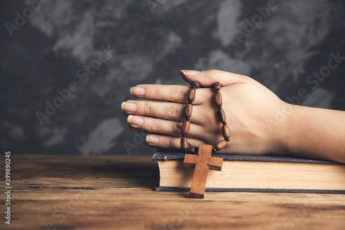 woman holding cross on Bible