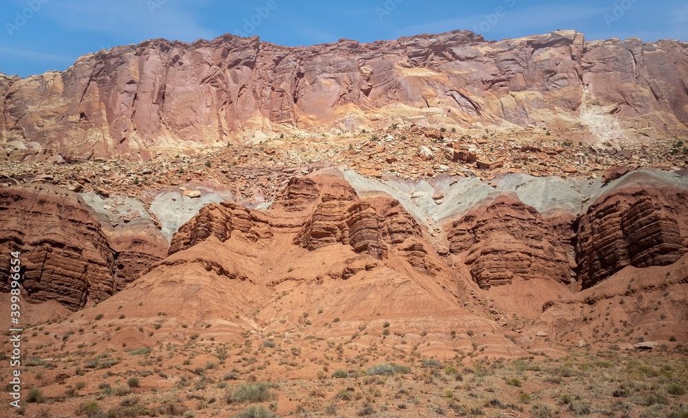 Sublime monoliths and towering sandstone cliffs on a hot partly cloudy summer day at Capitol Reef National Park in Southern Utah. Sublime monoliths and towering sandstone cliffs on a hot partly cloudy summer day at Capitol Reef National Park in Southern Utah.