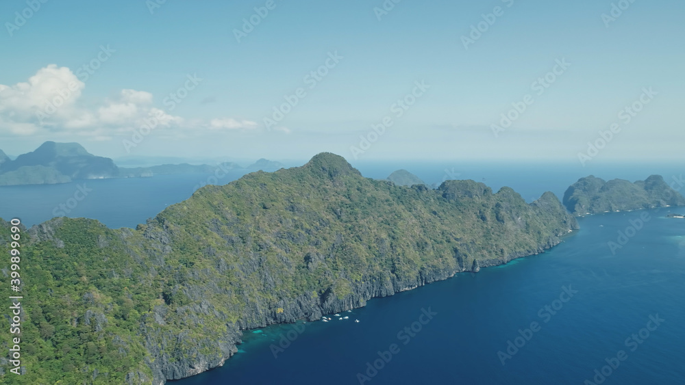 Blue sea bay at mountain islands of Visayas archipelago aerial view. Nobody nature seascape with deep blue water with turquoise shadows. Green tropic forest and plants at rock coast of El Nido Islets