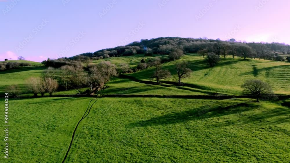 Arial drone shot up high of the english countryside and hill, as the sun rises. Drone panning up exposing a clear sky with long shadows. Very cinematic. Arial drone shot up high of the english countryside and hill, as the sun rises. Drone panning up exposing a clear sky with long shadows. Very cinematic.