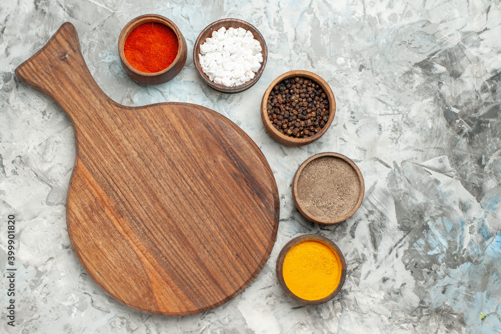 Half shot of healthy wooden cutting board different spices on white background Half shot of healthy wooden cutting board different spices on white background