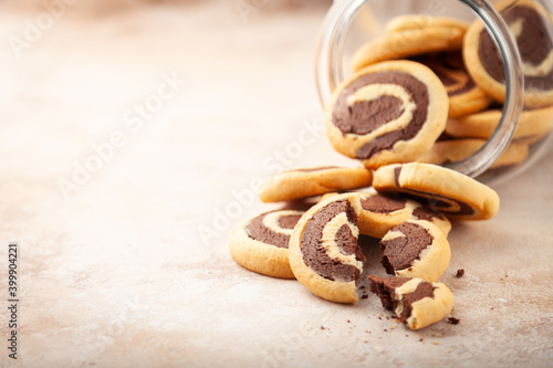 Sweet cookies with chocolate, scattered from transparent glass bank