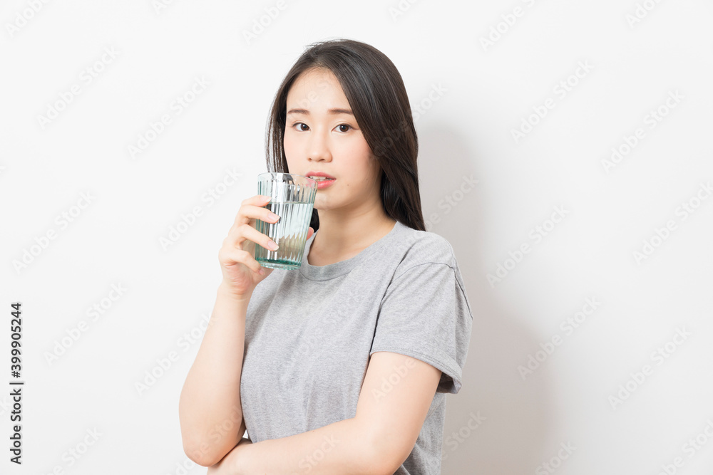 Beautiful portrait young asian woman smiling drinking a glass of water mineral on white background. Beautiful portrait young asian woman smiling drinking a glass of water mineral on white background.