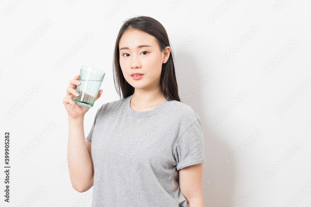 Beautiful portrait young asian woman smiling drinking a glass of water mineral on white background. Beautiful portrait young asian woman smiling drinking a glass of water mineral on white background.