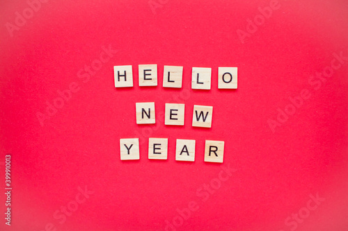 Hello new year. The inscription from wooden blocks on a bright red background. New Year. Christmas.
