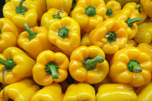 Photo A heap of fresh yellow capsicum for sale on a market stall, healthy food background