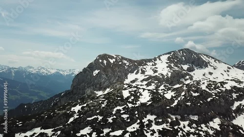 A drone shot of a snow-capped Alpine glacier and surrounding peaks in Schladming region, Austria. The slopes are partially covered with snow. Massive stony mountain. Many mountain chains in the back.
 photo