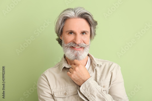 Mature man with grey hair on color background
