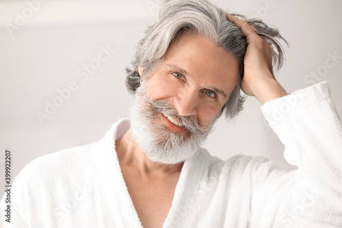Photography Portrait of mature man with grey hair on light background