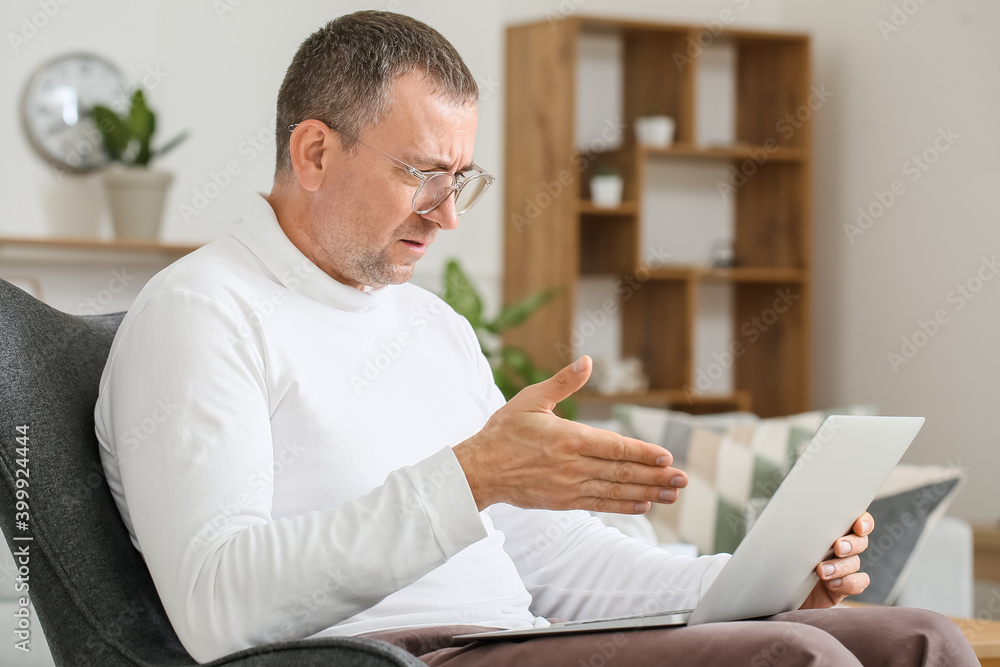 Portrait of male psychologist with laptop in office