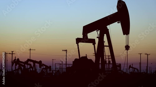 The sun rises behind oil pumps in California
