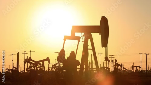 The sun rises behind oil pumps in California