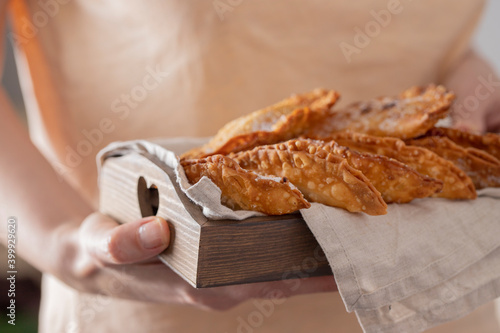 Female hand holding wooden try with Trucha, typical sweet consumed in Canary Islands during the Christmas time. photo
