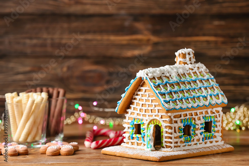 Gingerbread house with sweets on table