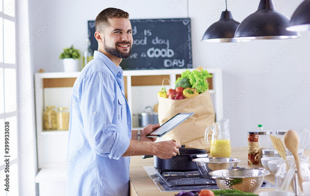 Smiling and confident chef standing in large kitchen Smiling and confident chef standing in large kitchen