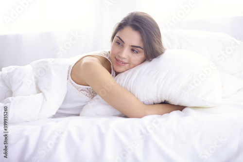 beautiful young woman basking in bed in the morning. Beautiful Model face looks sexy in camera