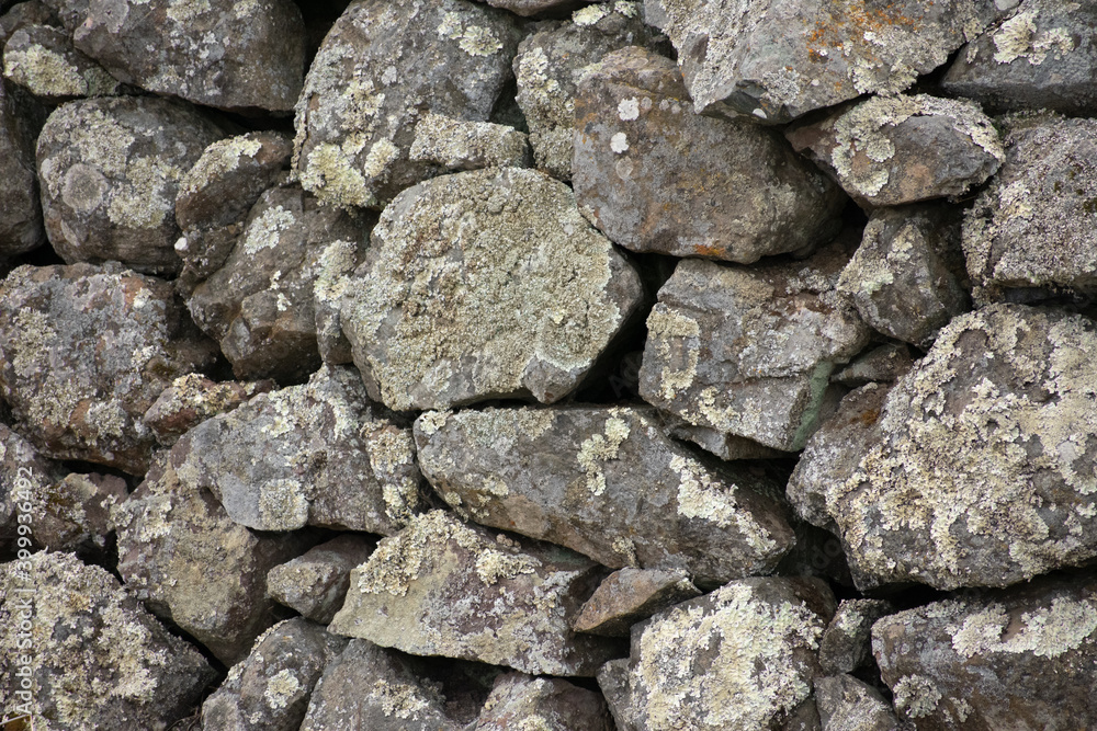 Closeup of a dry stone wall with lichen