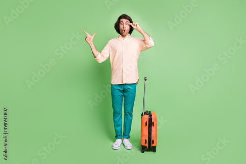 Full length body size view of amazed guy departing voyage demonstrating copy space pout lips isolated over bright green color background