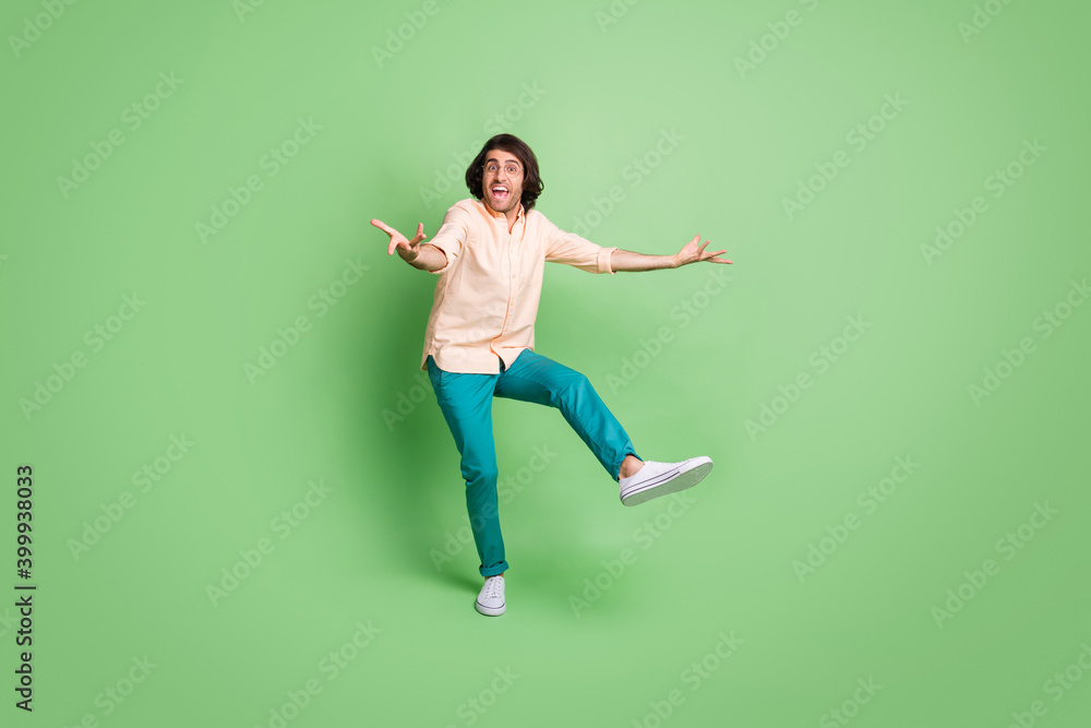 Full length body size view of nice cheerful funky guy dancing having fun isolated over bright green color background Full length body size view of nice cheerful funky guy dancing having fun isolated over bright green color background