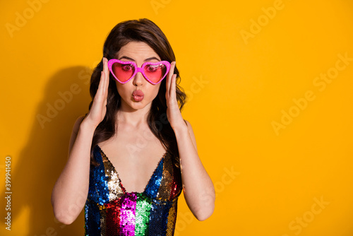 Photo of astonished with lips pouted plump girl see incredible summer sales touch heart shape spectacles wear glossy skirt isolated over bright shine color background