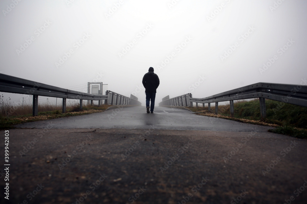 Heavy fog and cloud as a man heads out for a Sunday morning walk and crosses a bridge.