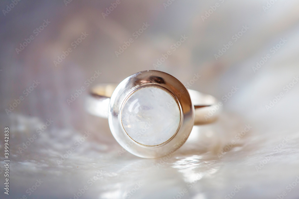 Silver ring with moon stone gemstone on pearl white background Silver ring with moon stone gemstone on pearl white background