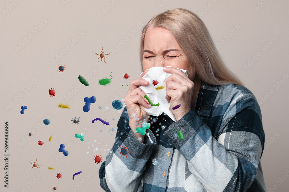 Sick mature woman on beige background. Microbes spreading Sick mature woman on beige background. Microbes spreading